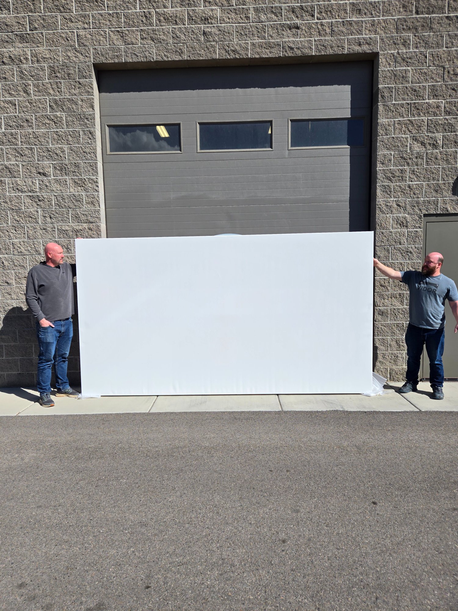 Two people holding a wide landscape blank canvas
